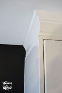 white cabinets with trim next to black walls