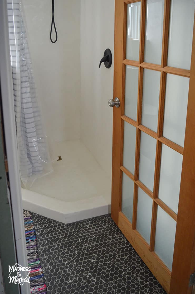 white bathroom shower with black floors
